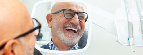 Man with glasses smiling in reflection