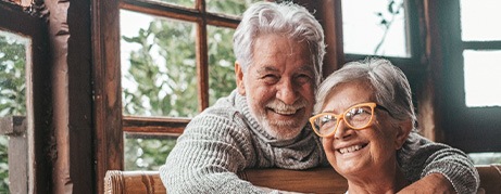 Older couple smiling with dental implants