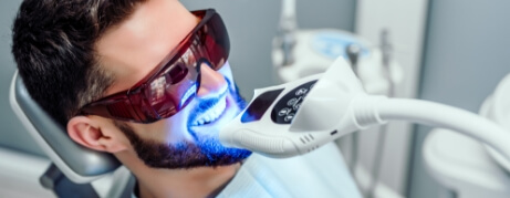 Man getting professional teeth whitening in dental office