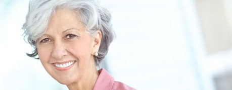 Smiling gray-haired woman in pink blouse