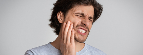 Man holding the side of his face in pain