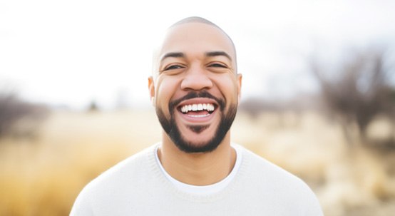 Man in white shirt smiling outside