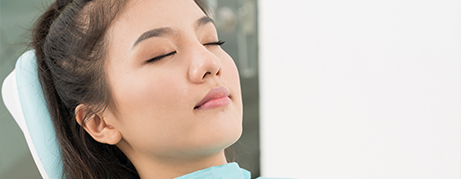 Woman with eyes closed relaxing in dental chair