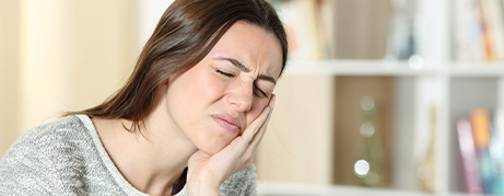 Woman holding her cheek in pain