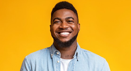 smiling man in front of a yellow background