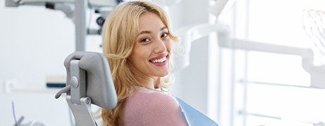 smiling woman sitting in a dentist’s chair